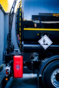 Detailed view of a hazardous material tank truck with warning sign, emphasizing safety.