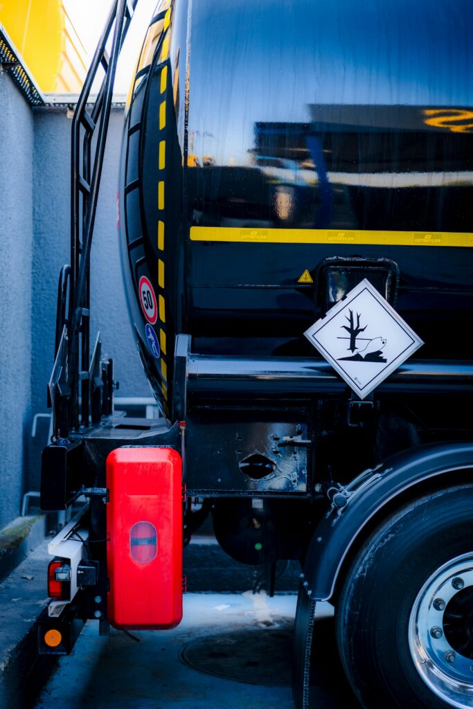 Detailed view of a hazardous material tank truck with warning sign, emphasizing safety.