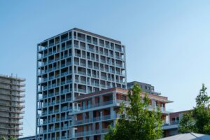 Contemporary residential buildings against a bright blue sky, showcasing modern design.