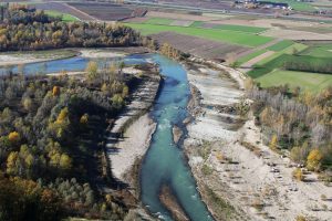 Aerial view of river and fields in Barbaresco, Piemonte during autumn, showcasing vibrant nature.